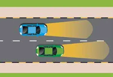 Night road: blue car on full beam being overtaken by another car