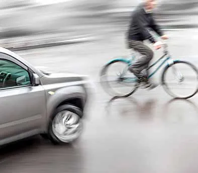 Photo of a car close to a cyclist on the road