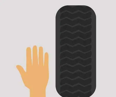 Hand held next to a tyre tread pattern
