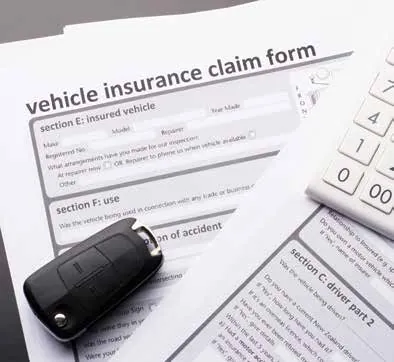 Vehicle insurance claim form with a car key and calculator